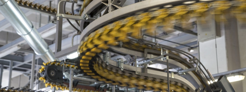 Blurred motion of empty conveyor belts for newspapers and magazines in large modern printing press.