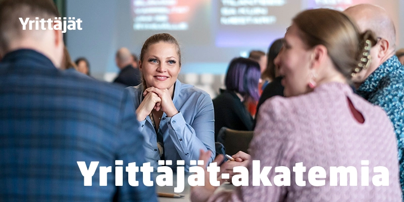 Yrittäjät-akatemian banneri, jossa ihmisiä istuu pöydän ympärillä keskustelemassa
